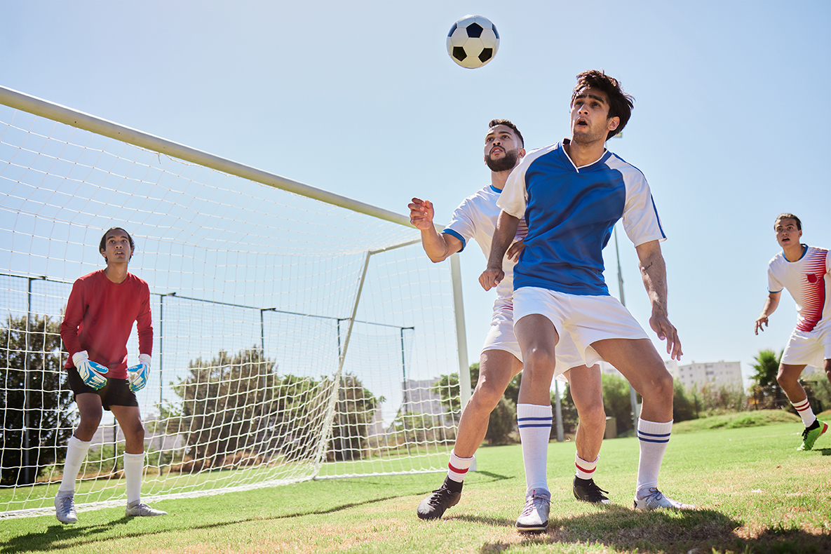 Soccer, sports and team playing game on an outdoor field for exercise, training and workout. Teamwork, football and healthy athletes practicing with ball on a grass pitch for match, fitness and skill.